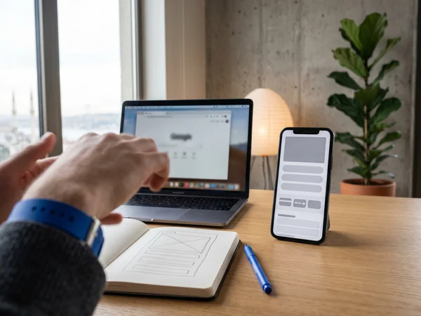 One responsive website rendering across desktop tablet and smartphone on a desk